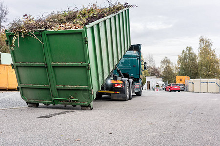 在回收中心装载废绿色废物的卡车集装箱图片