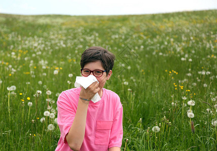 春天过敏的孩子用白手帕擤鼻涕图片