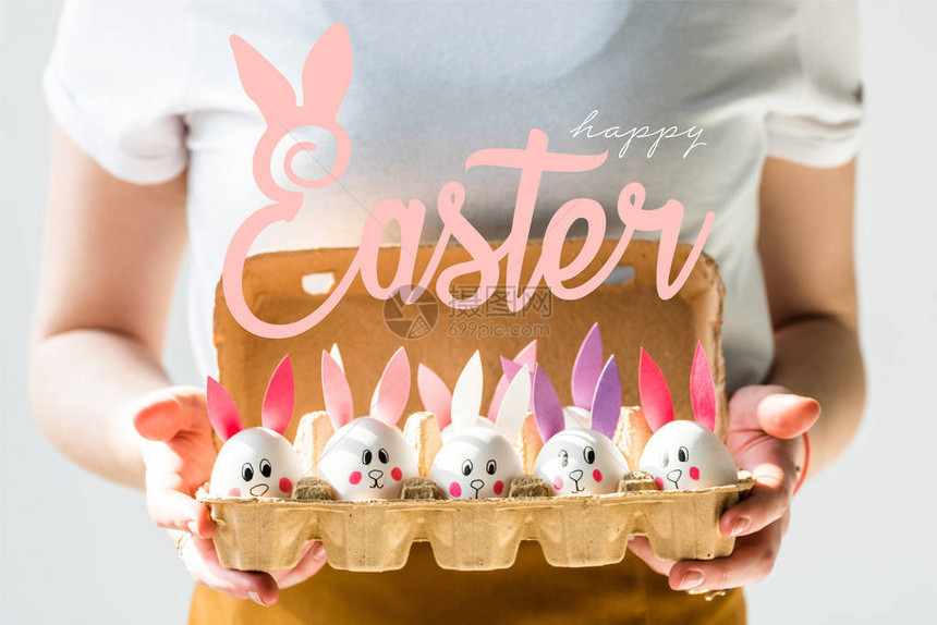 妇女持有鸡蛋箱鸡蛋脸和纸耳朵以及复活节快乐字母的图片
