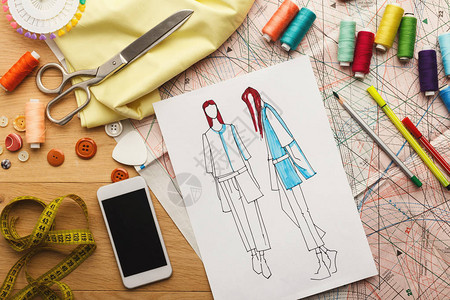 木桌上的衣服智能手机色板和线的手绘草图图片