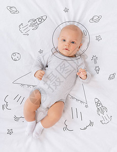 无辜的白种人婴儿宇航员躺在床上的俯视图图片