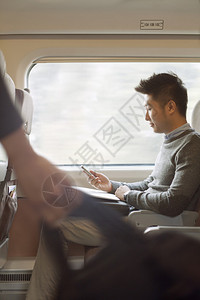 年轻人坐在火车上用手图片