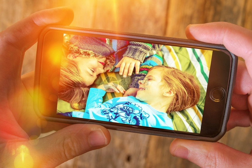 家庭假期回忆摄影存储在云中在线摄影存储概念白种人男子在他的智能手机上浏览去年夏天的图片