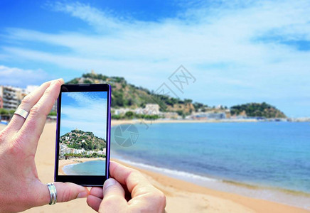 在布拉瓦海岸拍照时查看手机显示屏手里拿着手机拍照专图片