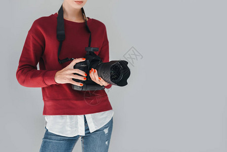 女专业摄影师在照片制室用数码摄影相机拍摄背景图片