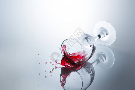 红酒从坠落的玻璃杯中溢图片