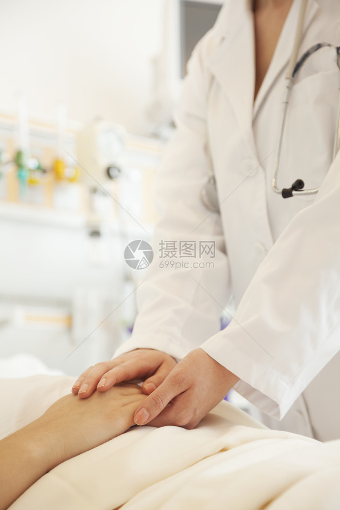 近距离紧贴的医生拿着一只病人的手躺图片