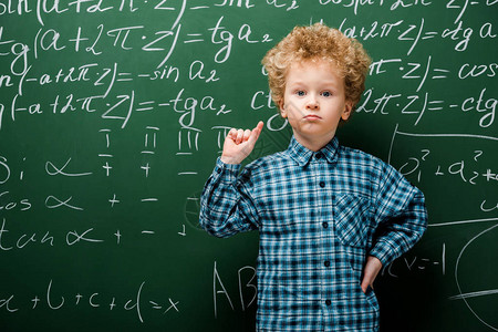 有数学公式的聪明小聪明站在黑板附背景图片