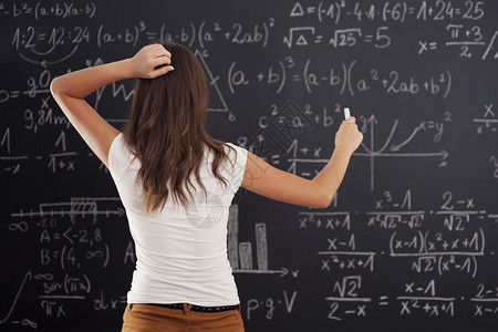 在黑板上看数学问题的年轻图片