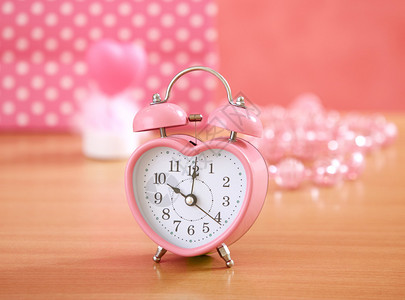 木桌上的粉红色时钟图片