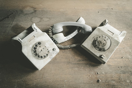 两部老旧的灰色电话挂在图片