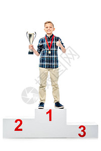 微笑的男孩站在获胜者的基座上图片