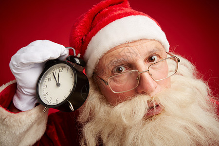 惊慌的圣诞老人带着闹钟显示圣诞节5分钟以红色背背景图片