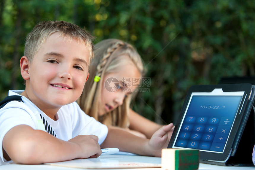 可爱的男孩学生在平板电脑户图片