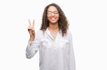 美丽的年轻西班牙女人露面用手指举起第二指头微笑着自信图片