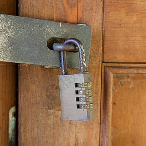 旧木门上的钢数字密码锁背景图片