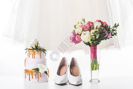 白色鞋子礼服和花束的婚礼蛋糕图片