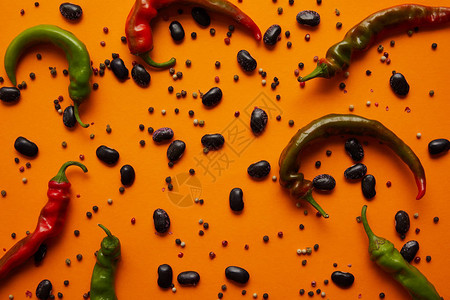 橙色背景中辣椒扁豆和胡椒的顶视图图片
