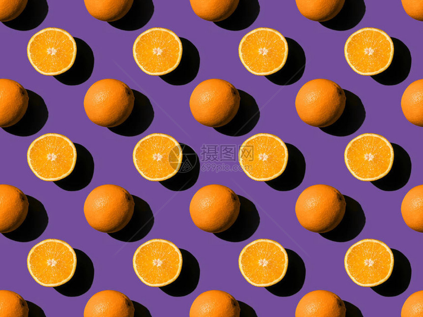 紫色上成熟的新鲜全橙和减半橙子的顶部视图图片