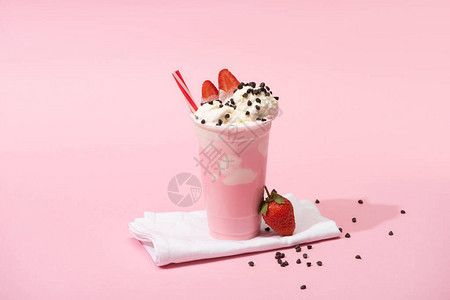 用粉红背景的餐巾纸上饮料草巧克力薯片和草莓的图片