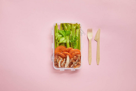 食物包装在食品容器和粉红色隔开的餐具中图片