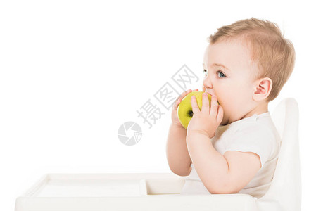 小男孩吃苹果在高椅子上的苹果孤图片