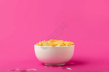 美味的玉米片子和奶粉盒中的饭碗中牛奶背景图片