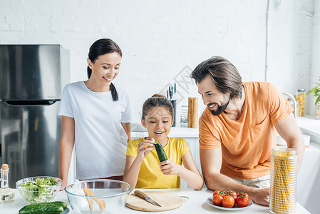 美丽的年轻家庭在一起烹饪健康晚餐图片