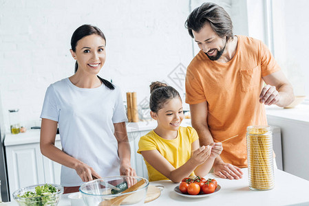 美丽的年轻家庭在厨房一起烹饪健康晚餐图片