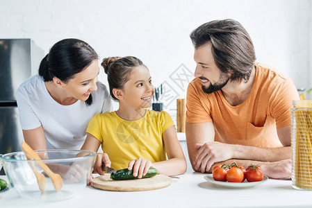 快乐的年轻家庭在厨房一起做健康的晚餐图片