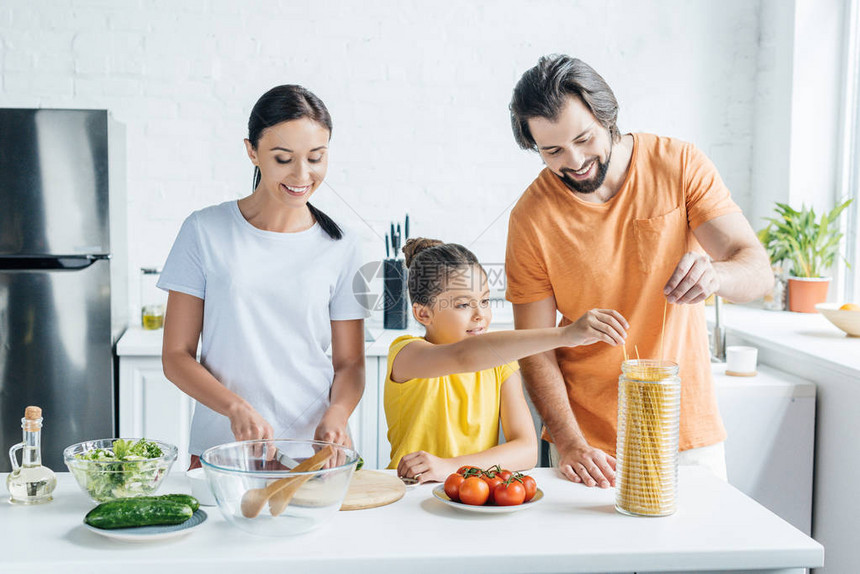 快乐的年轻家庭在厨房一起做健康饭一起图片