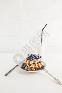 美味的早餐华夫饼配蓝莓和牛奶图片