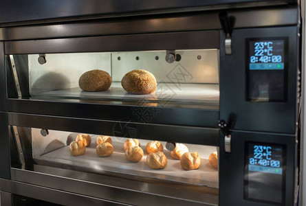在面包店的自动烤箱中烤面包图片