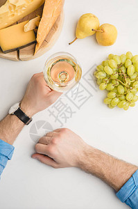以葡萄酒杯木板上不同种类的奶酪和白色水果裁图片