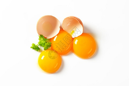 三个鲜蛋黄和空蛋壳背景