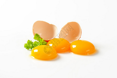 三个鲜蛋黄和空蛋壳背景