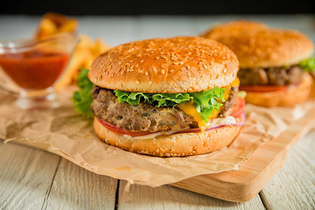 汉堡配烤牛肉沙拉奶酪和切菜板上的番茄图片