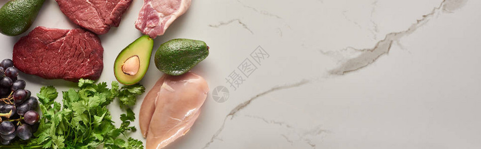 大理石表面带复制空间的生肉鸡片鳄梨绿菜和葡图片