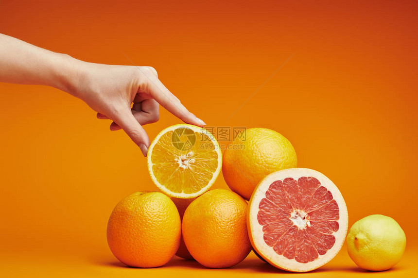 人手的裁剪镜头和橙子上新鲜成熟的柑橘类水果图片