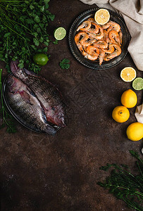 新鲜生鱼虾含柠檬的草药和黑图片