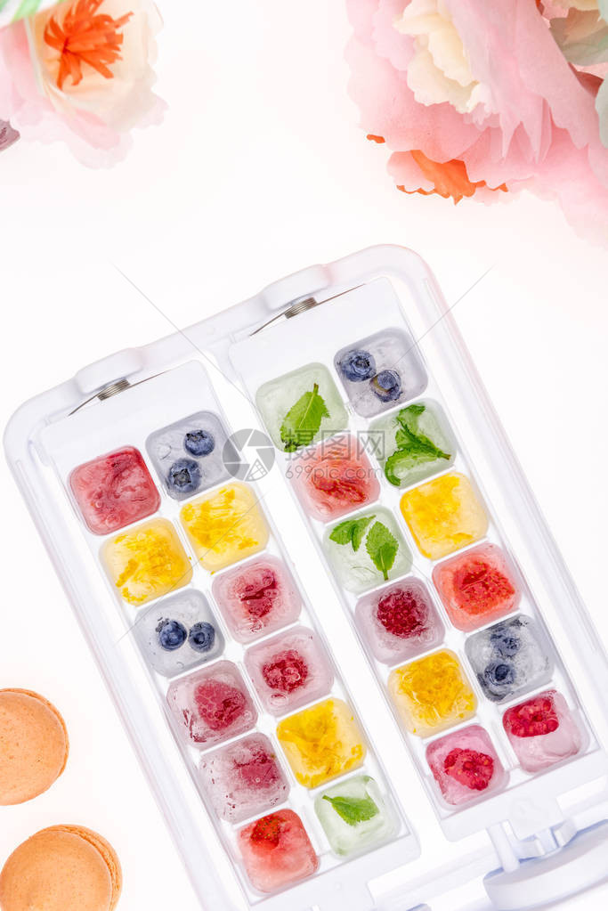 果子和水果装在冰块中鲜花和白方的石图片