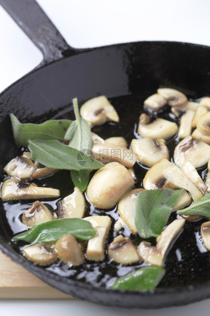 在煎锅中用鼠尾草炒蘑菇图片