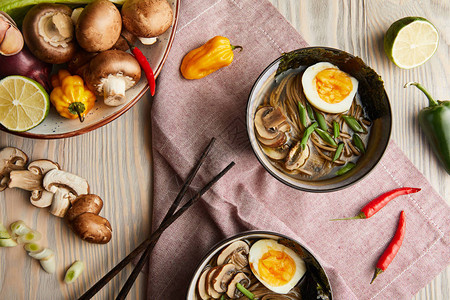 碗中传统的辣拉面用筷子和蔬菜配餐巾图片