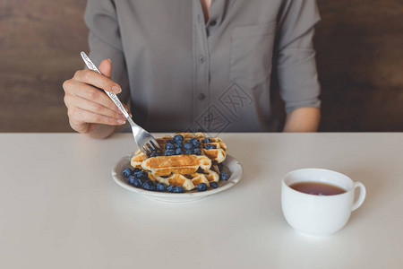 女人早餐吃华夫饼和蓝莓的短片图片