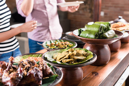 在印度尼西亚餐厅自助餐中选择食物的亚图片