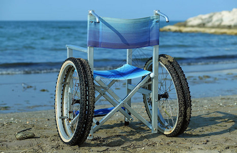 夏季在海边轮椅上坐着大轮子在沙滩图片