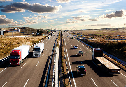 国际货运卡车和汽车在公路上行驶图片