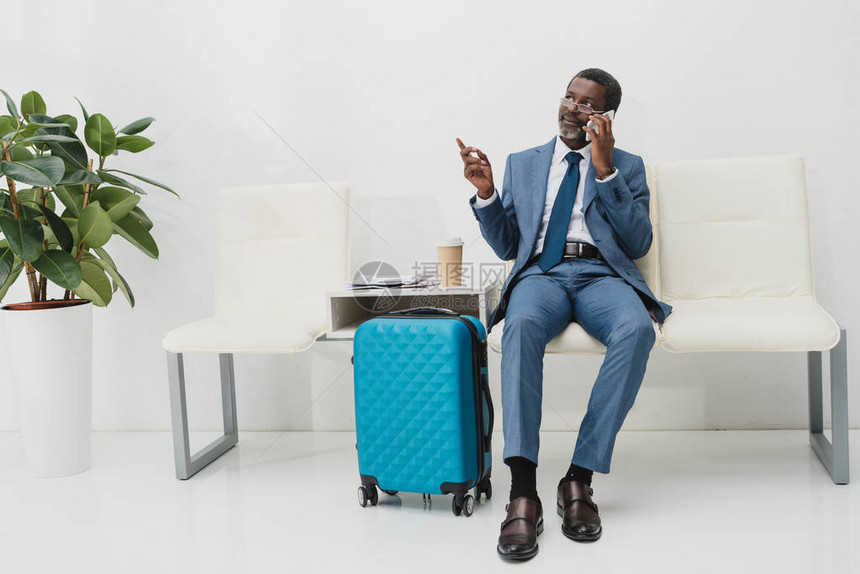 非洲中年非裔美国商人在机场等候时用智能手机聊天Name图片