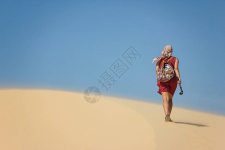 在沙漠中走着背包的孤独女人图片