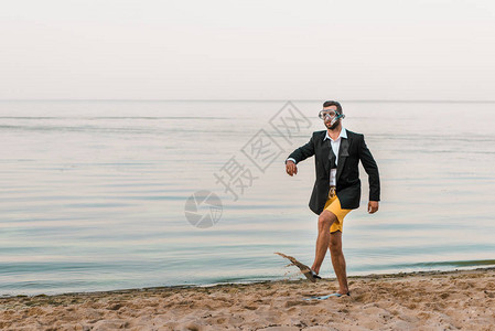 穿着黑外套和短裤的男子在海边带着游泳面图片